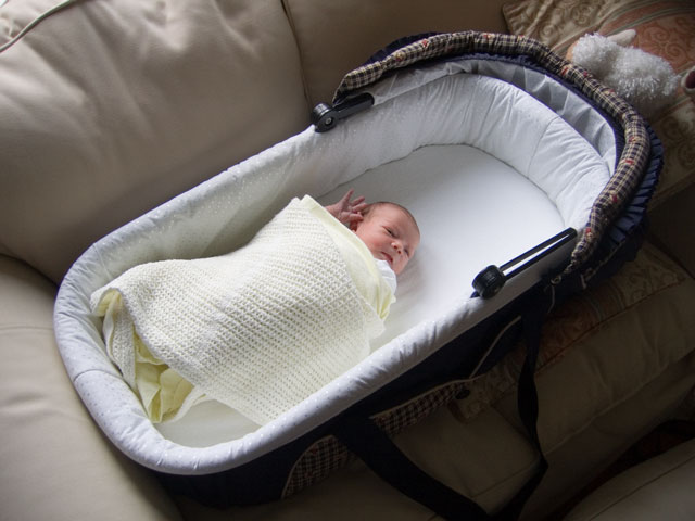 Jessica in her carrycot on the sofa